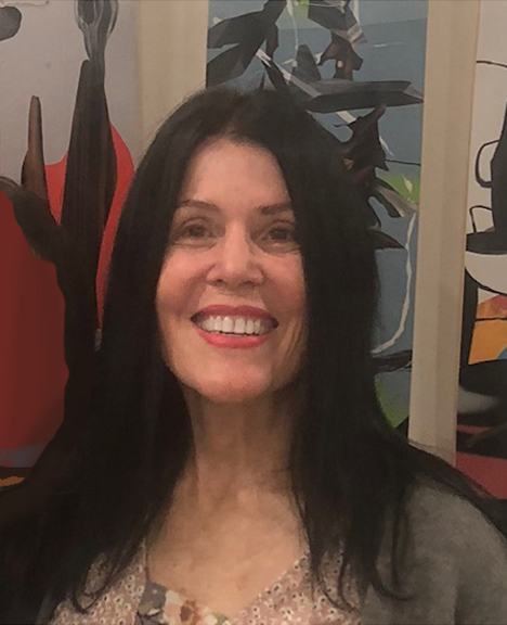 Image of Linda Kozar with a book shelf in background