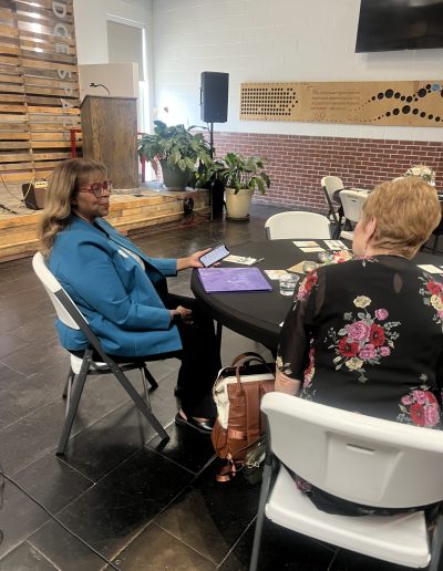 2 women sitting and talking in a church setting for the women at the well event