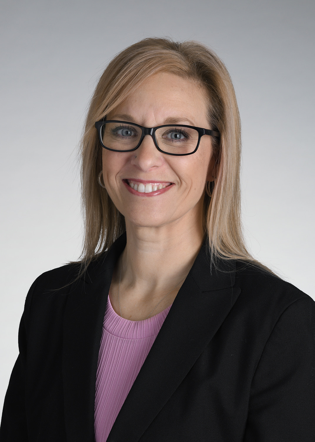 Image of Linda Kozar with a book shelf in background